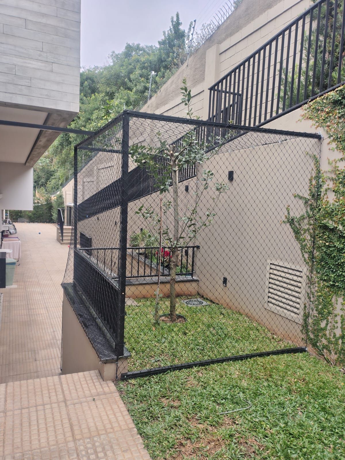 Gatil (catio) sob medida com tela de proteção instalado em área externa para gatos